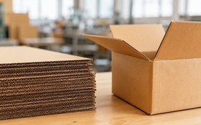 Стопка листов гофрокартона и открытый гофрокороб на производстве Стопка листов гофрокартона и открытый гофрокороб на производстве